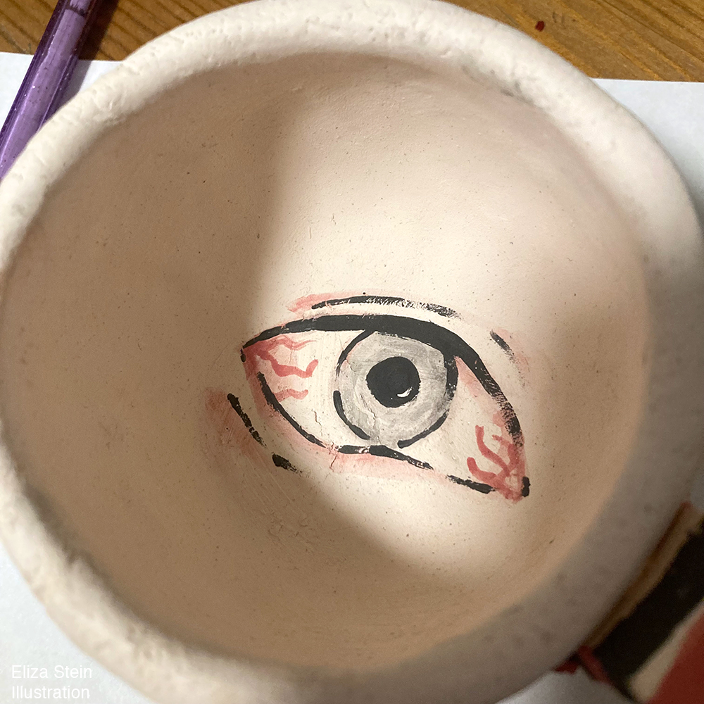 ceramic mug with bloodshot eye painted in the center