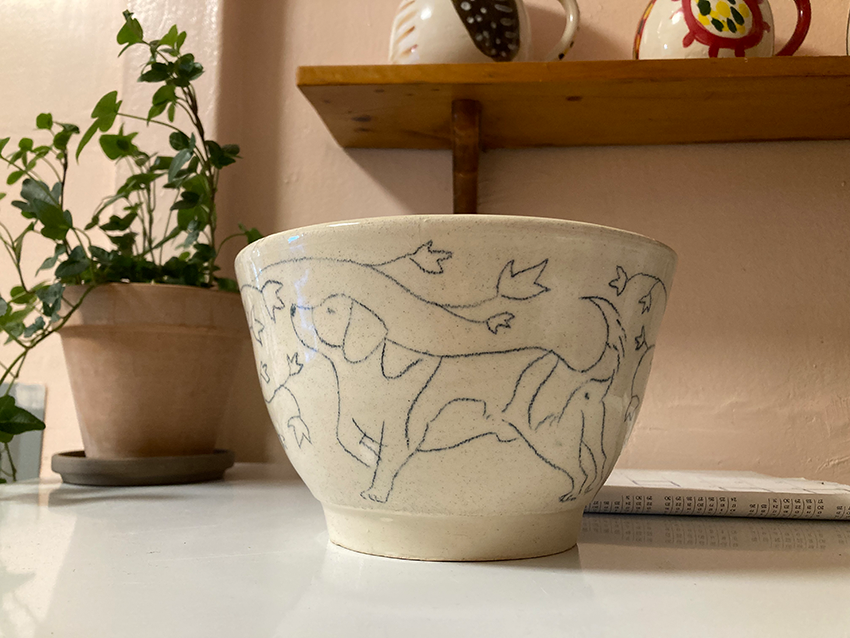 flowerpot with drawing of hound dog sniffing ivy leaves